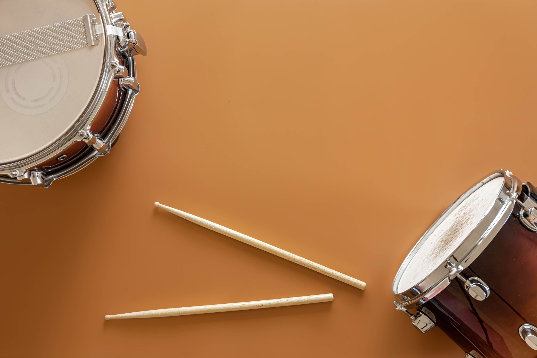 drums-and-drum-sticks-on-brown-background-top-view_2